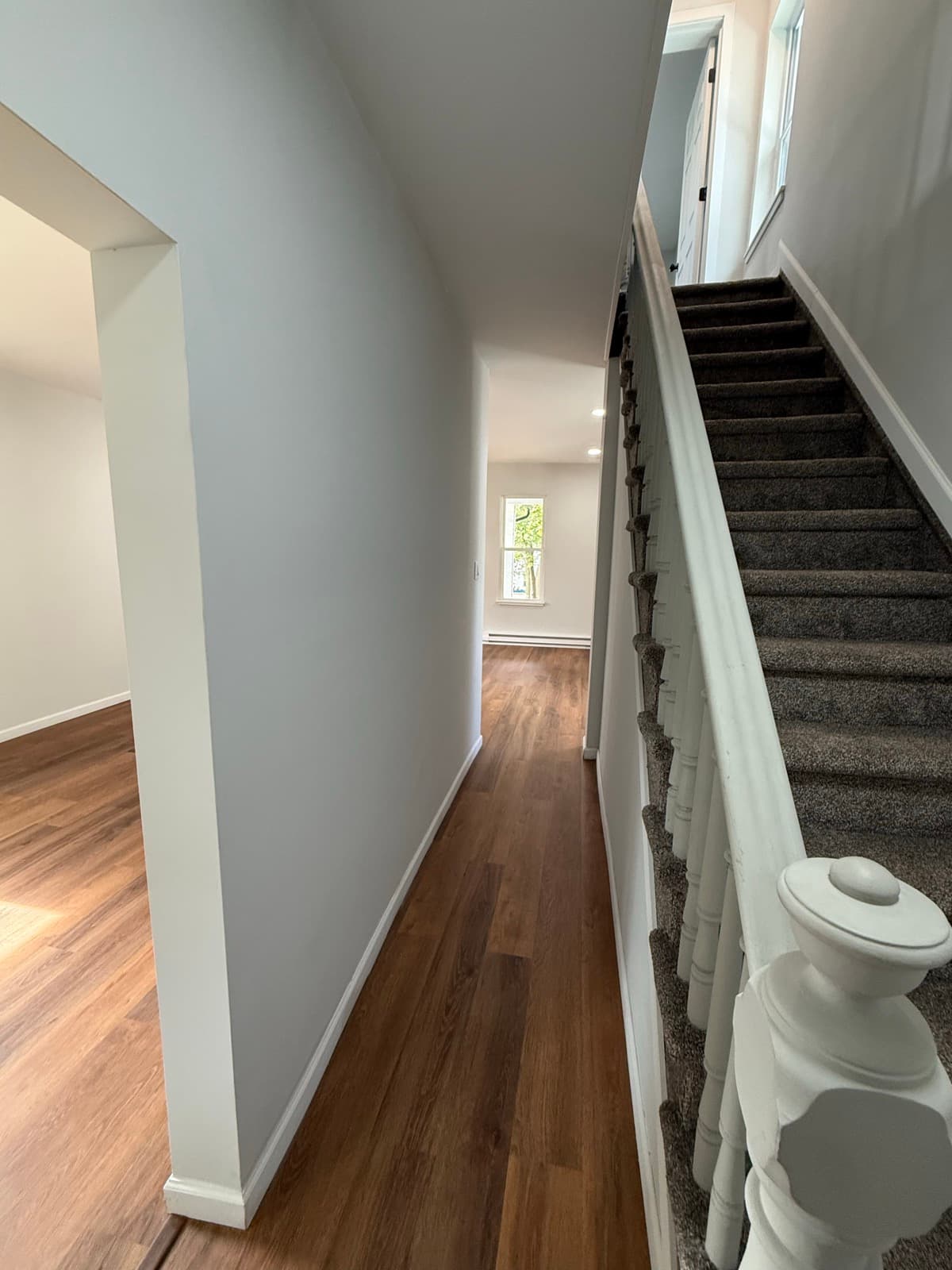 Finished entry and staircase at 523 Grove Street with refreshed walls and flooring